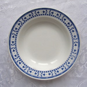 May include: A white ceramic soup bowl with a blue and white floral pattern around the rim.