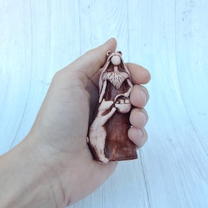 May include: A hand-painted ceramic figurine of a bearded man holding a basket and a small animal. The figurine is brown and white.
