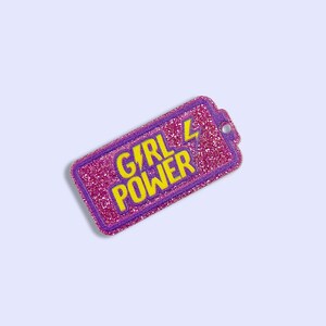 May include: A pink and purple glitter battery with the text "GIRL POWER" in yellow letters and a yellow lightning bolt.