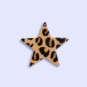 May include: A five-pointed star-shaped ornament with a leopard print pattern in shades of brown and black.
