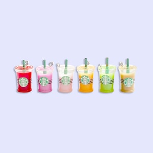 May include: Six colorful plastic cups with straws and a Starbucks logo. The cups are red, pink, light pink, orange, green, and beige.