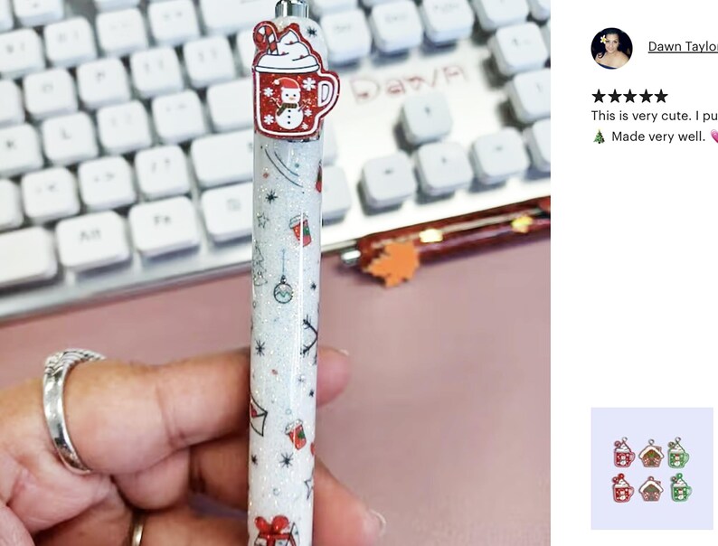 May include: A white glitter pen with a red and white snowman design on the top. The pen has a variety of Christmas-themed designs, including a snowman, a Christmas tree, and a gift box.