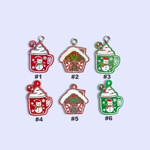 May include: Six Christmas ornaments, three are red mugs with white whipped cream and a snowman, and three are gingerbread houses with red and white candy canes. The ornaments are numbered 1 through 6.