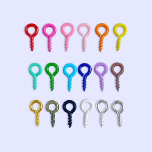 May include: A set of 18 colorful eye hooks, each with a different color. The hooks are arranged in three rows of six, with the colors gradually changing from red to orange, yellow, green, blue, purple, and brown.