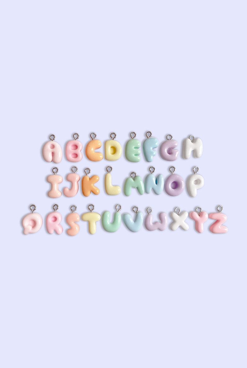 Peut inclure: Un ensemble de 26 breloques en forme de lettres de couleur pastel, chacune avec une boucle argent&eacute;e pour s'attacher &agrave; un collier, un bracelet ou un autre bijou. Les lettres sont dispos&eacute;es en ordre alphab&eacute;tique, chaque lettre &eacute;tant d'une couleur diff&eacute;rente.