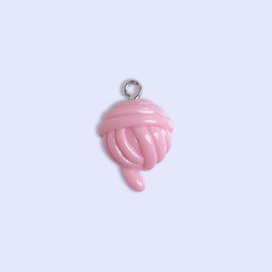 May include: A pink yarn ball charm with a silver loop for hanging.