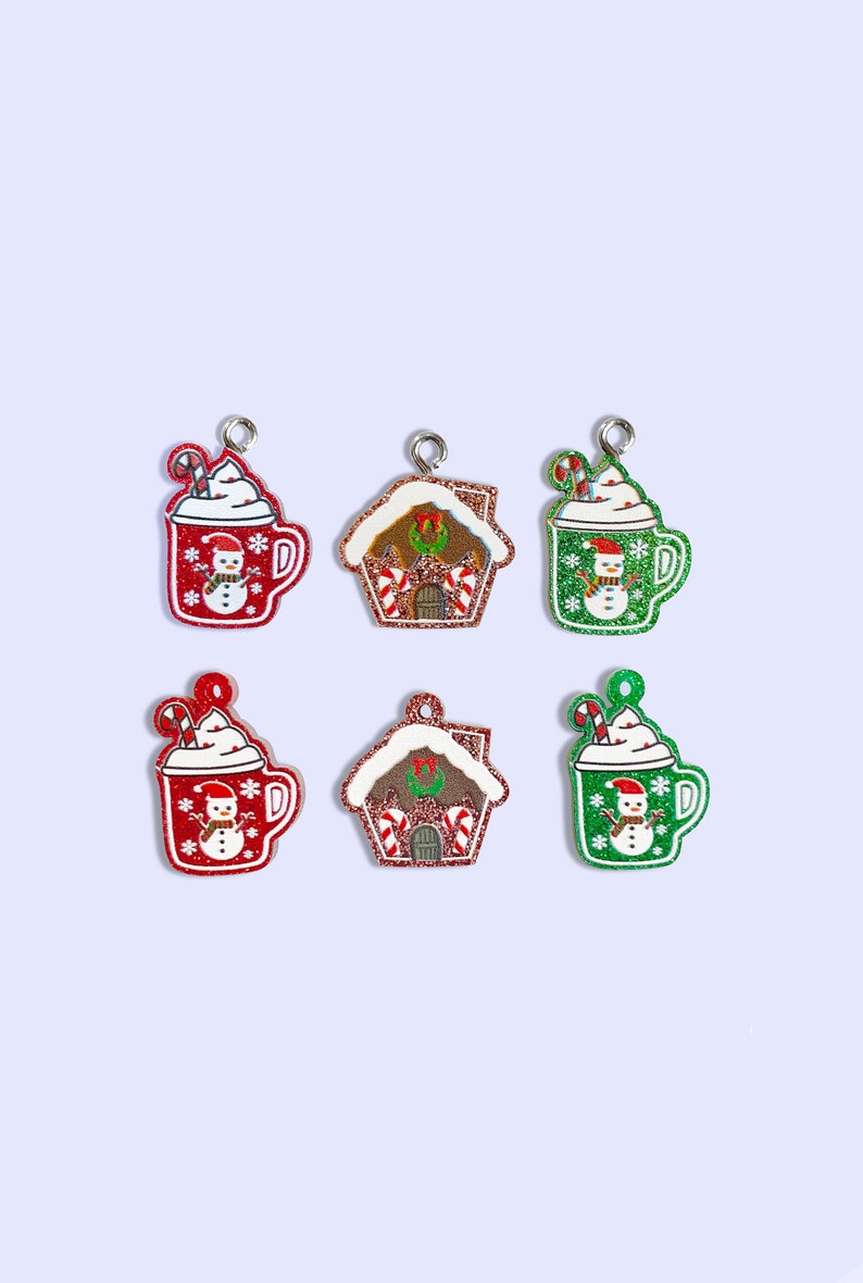 May include: Six Christmas-themed charms, including two red and two green mugs with a snowman design and two gingerbread houses with candy cane accents.