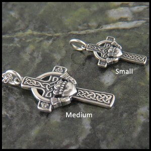 May include: Two silver Celtic cross pendants with a shamrock and a claddagh design. The smaller pendant is labeled "Small" and the larger pendant is labeled "Medium".