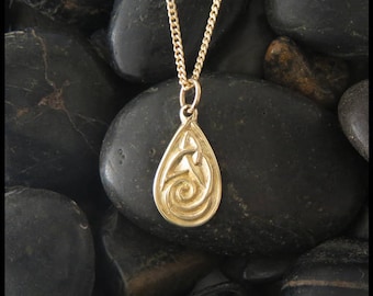 May include: A gold pendant necklace with a teardrop-shaped charm featuring a Celtic knot design.
