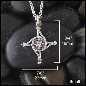 May include: Silver Celtic knot cross pendant, 7/8 inches wide and 3/4 inches tall. The pendant features a intricate knot design with a spiral in the center.