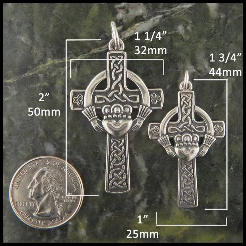 May include: Two silver Celtic cross pendants with a Claddagh design. The larger pendant measures 1 3/4 inches and the smaller pendant measures 1 1/4 inches. Both pendants are shown next to a US quarter for size comparison.