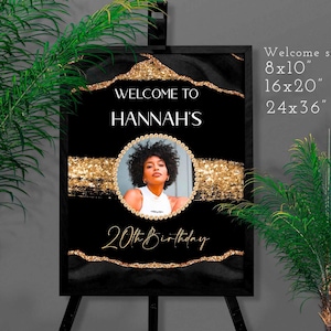 May include: Black and gold welcome sign for a 20th birthday celebration. The sign features a photo of a woman, the name "Hannah's", and the text "Welcome to" and "20th Birthday". Available in 8x10", 16x20", and 24x36" sizes.