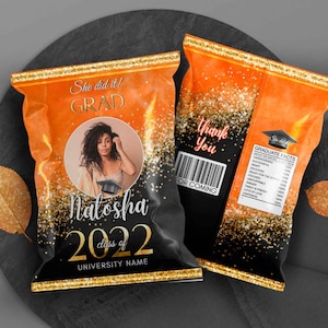 May include: Graduation-themed chip bag design in orange, black, and gold. Features a photo of a graduate, the name "Natasha", and "Class of 2022". Includes text "She did it! GRAD" and "Thank You".