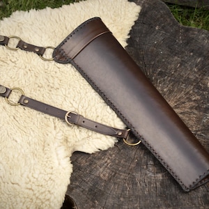 Leather side quiver with adjustable straps, hand-made with laced edges.