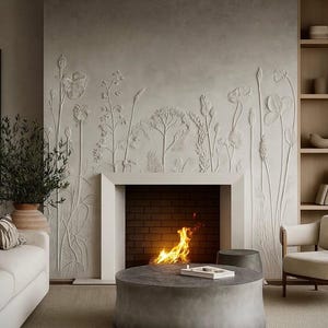 May include: A fireplace surround featuring a light gray wall with a raised, white botanical relief sculpture of wildflowers and grasses. The fireplace has a dark brick interior with a burning fire, positioned behind a round, gray stone coffee table.