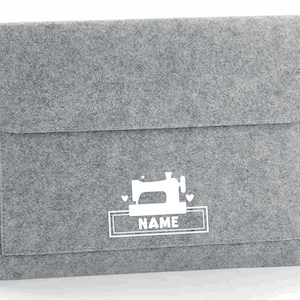 May include: Gray felt laptop sleeve with a white sewing machine design and the word "NAME" in a white rectangle.