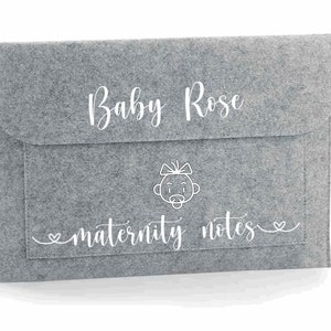 May include: Grey felt folder with a pocket and a white outline of a baby with a bow and dummy. The text "Baby Rose" and "maternity notes" is written in white cursive.