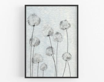 May include: A framed art print showing a watercolour painting of dandelion-like flowers. The flowers are white and grey, with thin black stems against a textured, light blue background. The artwork is enclosed in a black frame.