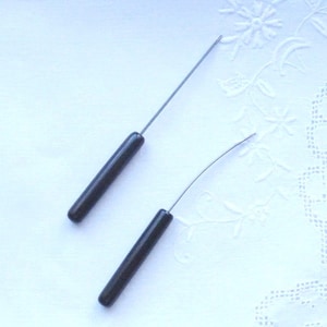 Könnte beinhalten: Zwei Werkzeuge mit schwarzen Griffen und Metallspitzen. Das Werkzeug links hat eine gerade Spitze und das Werkzeug rechts eine gebogene Spitze.