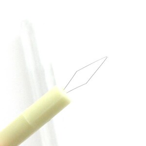 May include: A white plastic needle threader with a diamond-shaped metal loop at the end.