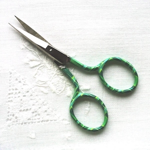 May include: Green and blue patterned embroidery scissors with silver blades.