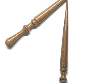 Peut inclure: Deux aiguilles à tricoter en bois tourné à la main avec une finition lisse et polie et un grain de bois brun naturel. Chaque aiguille présente une pointe effilée à une extrémité et un manche arrondi décoratif avec des anneaux sculptés.