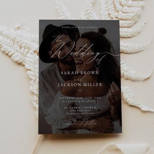 May include: Wedding invitation with a black background and a photo of a couple in the center. The text reads "The Wedding of Sarah Brown and Jackson Miller" with the date and location below.