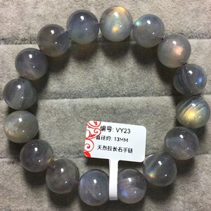 May include: A bracelet made of smooth, round, greyish-blue labradorite beads with iridescent flashes. A white tag is attached, displaying the text "编号: VY23", "直径约: 13MM", and "天然拉长石手链", indicating a bead diameter of approximately 13 mm.