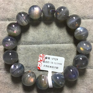 May include: A bracelet composed of round, polished grey beads with iridescent flashes of blue, gold, and purple. A white tag is attached, displaying the text '编号: VY29', '直径约: 13-13.7MM', and '天然拉长石手链', indicating a bead diameter of 13-13.7 mm.