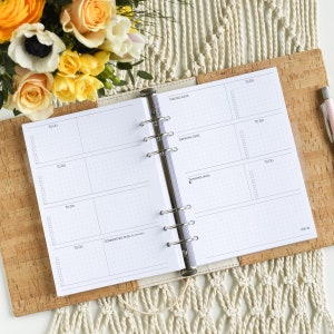 Könnte beinhalten: Ein weißer Planer mit einem Kork-Umschlag und einem silbernen Ringbuch. Der Planer hat ein wöchentliches Layout mit Abschnitten für jeden Tag der Woche. Die Wochentage sind in Deutsch beschriftet: Freitag, Samstag, Sonntag, Donnerstag.
