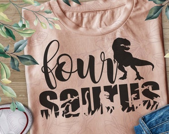 May include: A pink t-shirt with the text "four saurus" in black. The text is surrounded by dinosaur silhouettes.