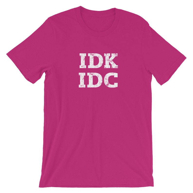 May include: A pink t-shirt with the text "IDK IDC" in white distressed lettering.