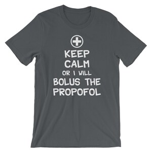Puede incluir: Camiseta gris oscuro con texto blanco que dice "Keep Calm or I Will Bolus the Propofol" y un s&iacute;mbolo de cruz m&eacute;dica blanca.
