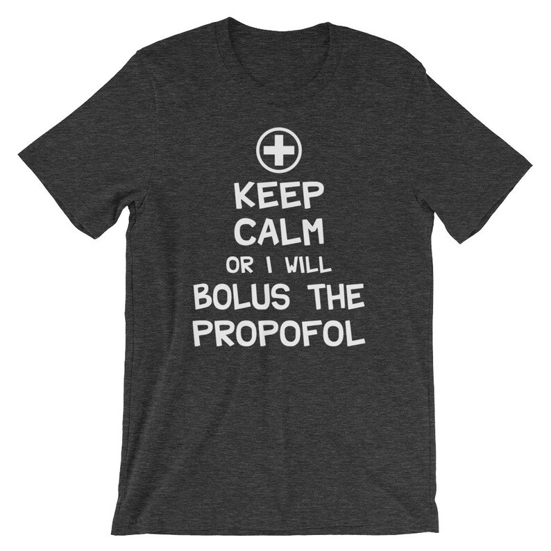 Puede incluir: Camiseta gris oscuro jaspeada con texto blanco que dice "Keep Calm or I Will Bolus the Propofol". Un s&iacute;mbolo de cruz m&eacute;dica blanca est&aacute; por encima del texto.