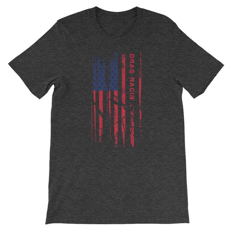 May include: A dark heather grey t-shirt featuring a distressed American flag design with the text "DRAG RACIN'" printed vertically on the right side of the flag.
