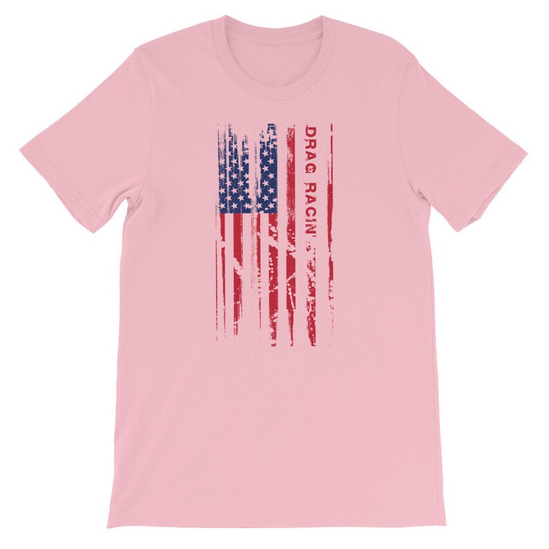 May include: Pink t-shirt featuring a distressed American flag design with the text "DRAG RACIN'" printed vertically on the right side of the flag.