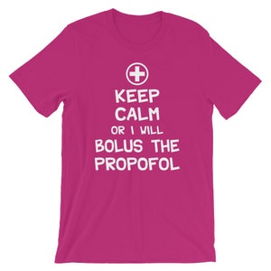 Puede incluir: Camiseta rosa con texto blanco que dice "Keep Calm or I Will Bolus the Propofol" y un signo m&aacute;s blanco.