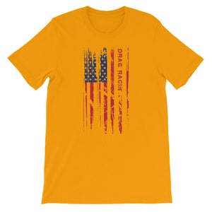 May include: A yellow t-shirt featuring a distressed American flag design and the text "DRAG RACIN'" in red.