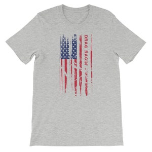 May include: A heather grey t-shirt featuring a distressed American flag design and the text "DRAG RACIN'" in red.