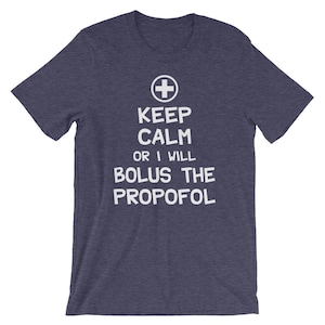Puede incluir: Una camiseta azul marino con texto blanco que dice "Keep Calm or I Will Bolus the Propofol" y un signo m&aacute;s blanco sobre el texto.