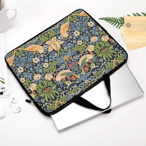 Puede incluir: Funda para portátil con un colorido estampado floral y de pájaros en tonos azules, verdes, amarillos y naranjas. La funda tiene un asa y cremallera negras, y un portátil es parcialmente visible en su interior.