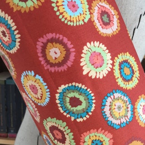 Puede incluir: Tela roja con un patr&oacute;n repetitivo de c&iacute;rculos multicolores de estilo tie-dye.