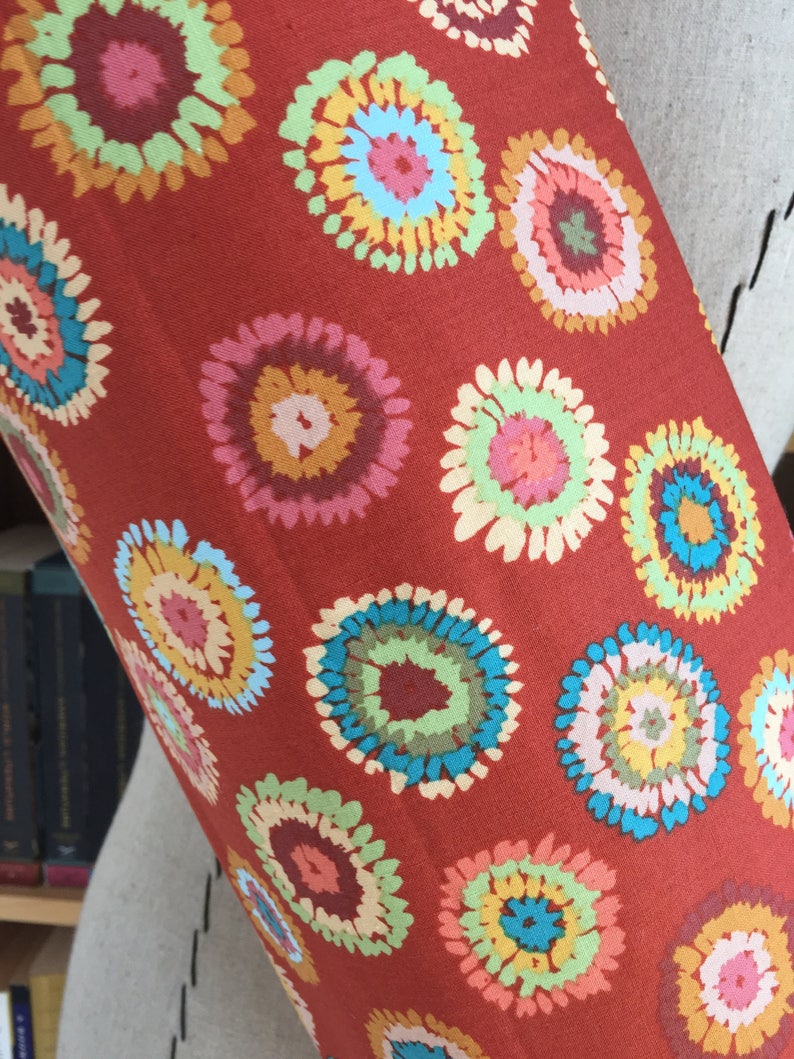 Puede incluir: Tela roja con un patr&oacute;n repetitivo de c&iacute;rculos multicolores de estilo tie-dye.