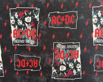 May include: A black fabric featuring a repeating pattern of AC/DC band imagery. The design includes the text AC/DC and HIGHWAY TO HELL in red, alongside illustrations of band members and scattered red lightning bolts on a dark, textured background.