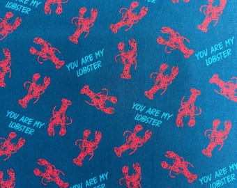 May include: A teal fabric featuring a repeating pattern of red lobster illustrations and the text YOU ARE MY LOBSTER printed in a light blue sans-serif font. The design is oriented in various directions across the surface of the textile material.