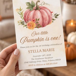 May include: A rectangular birthday invitation card featuring a watercolor illustration of a pink pumpkin with green leaves and orange flowers. The text reads: Our little Pumpkin is one! Please join us for the 1st birthday celebration of STELLA MARIE.