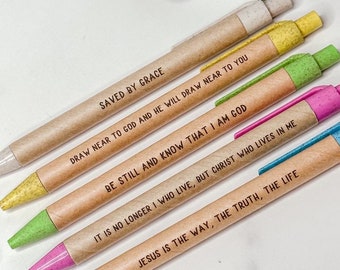 May include: Set of six brown pens with inspirational quotes printed on them. The quotes are: "Saved by Grace", "Draw near to God and he will draw near to you", "Be still and know that I am God", "It is no longer I who live, but Christ who lives in me", "Jesus is the way, the truth, the life", and "Warfel Designs".
