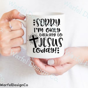 May include: White ceramic mug with a black design that says "Sorry I'm only talking to Jesus today!" with a cross and sunburst behind the word "Jesus".