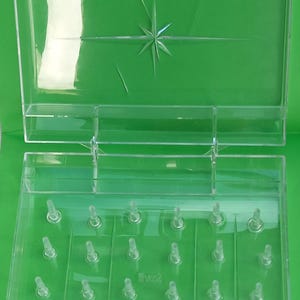 May include: A clear plastic storage box with a star design on the lid. The box has 18 compartments and is labelled "DRILL SIZE 08 10002 NO. 387.04".