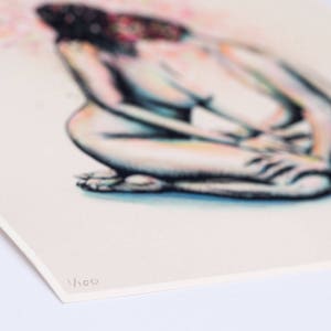 May include: A print of a seated figure, rendered in soft pencil strokes with a focus on the body's form. The artwork features a muted color palette with hints of pink and blue. The print is numbered 1/100.
